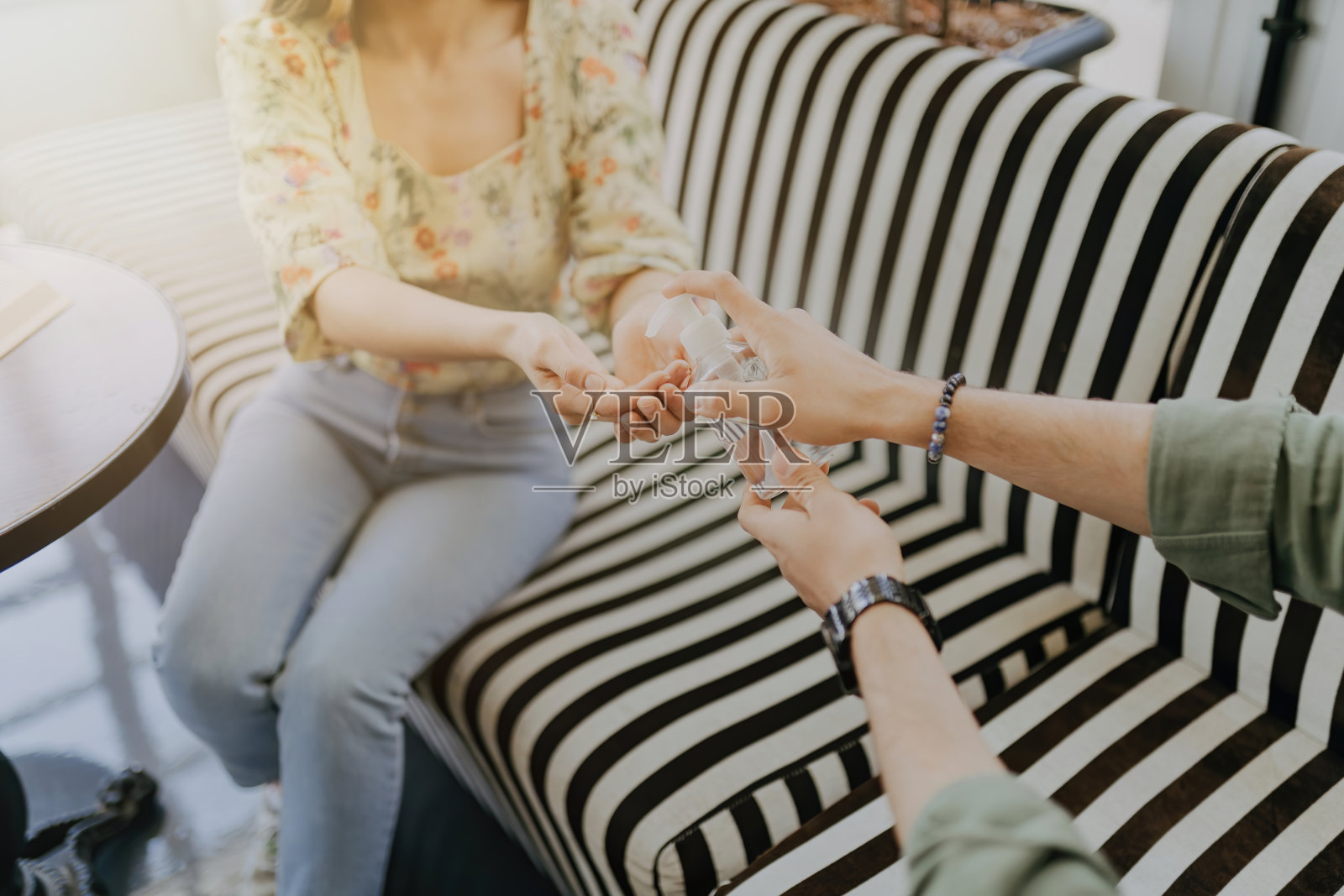 一对年轻夫妇在咖啡店使用消毒剂照片摄影图片