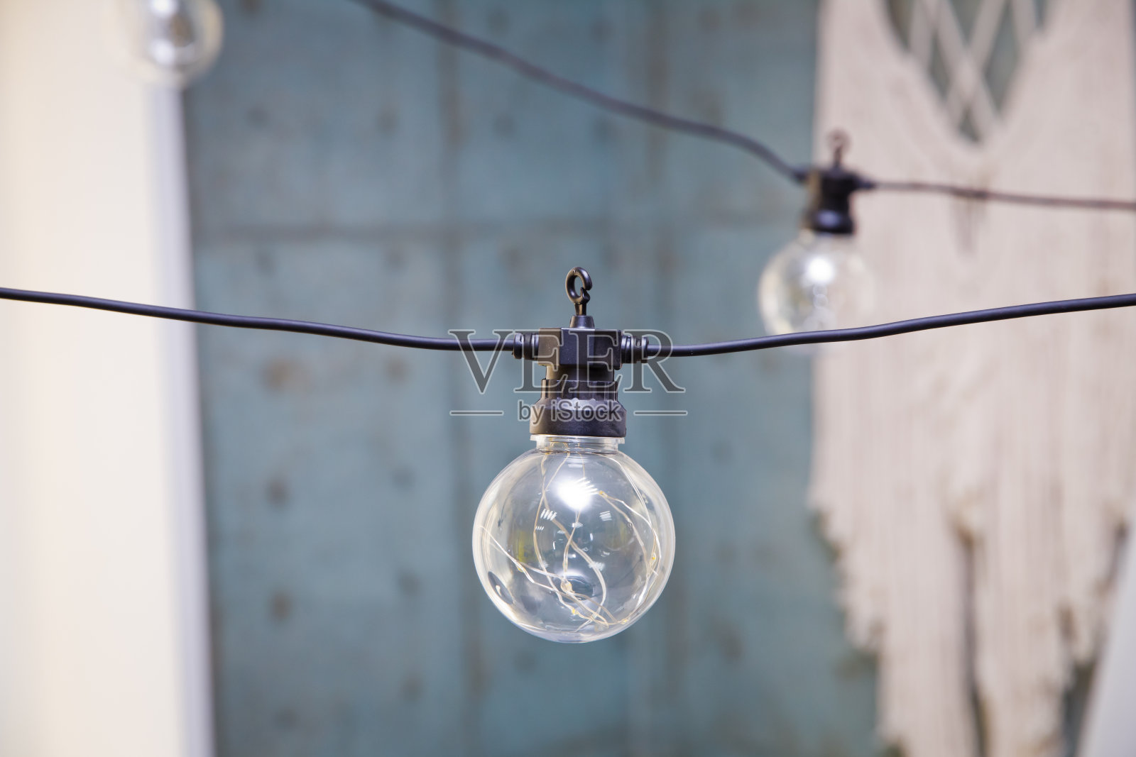 白天，酒吧里挂着装饰用的灯泡。一个灯泡。街道花环的元素。阁楼内部的爱迪生灯。照片摄影图片