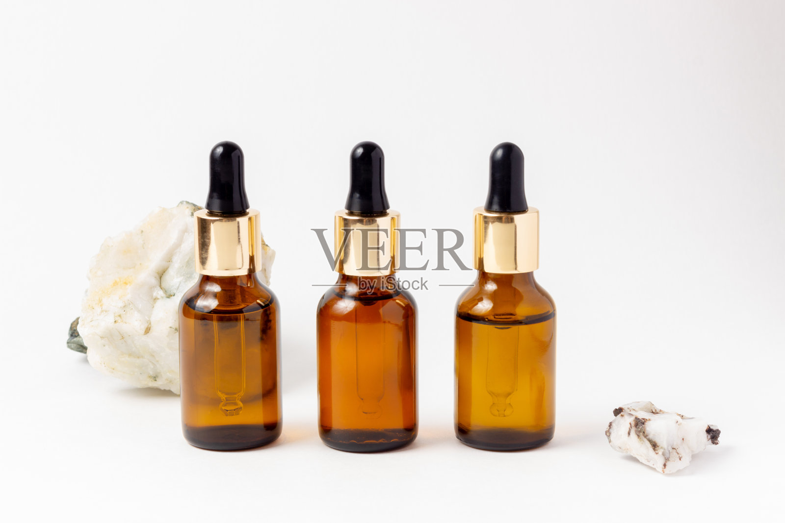 琥珀瓶精油和化妆品。白色背景上的玻璃瓶。一个滴管，一个带喷雾器的瓶子照片摄影图片