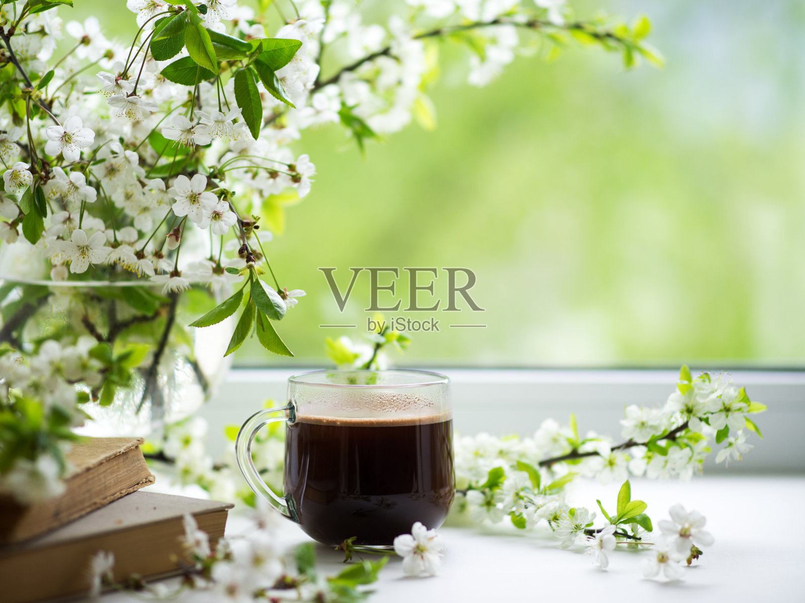 春天的静物在窗前，盛开着一束白色的樱桃枝。复活节或早餐的概念。浓缩咖啡在一个玻璃杯子复制空间照片摄影图片