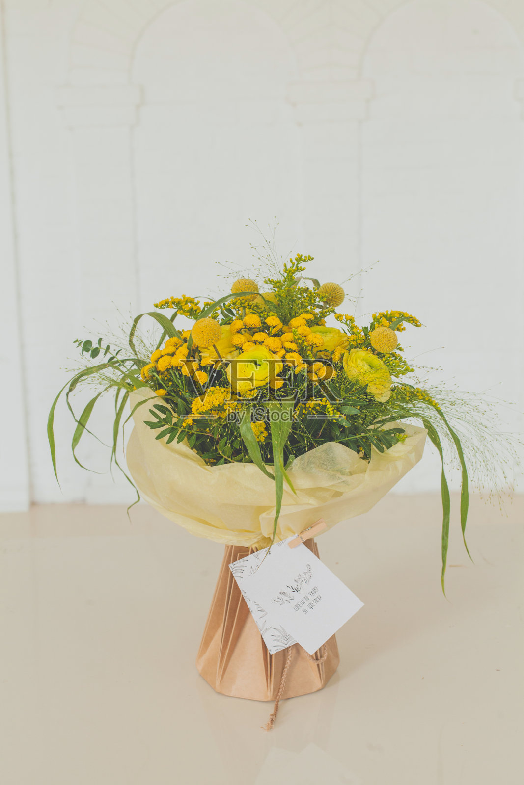黄色的花在牛皮纸袋上白色照片摄影图片