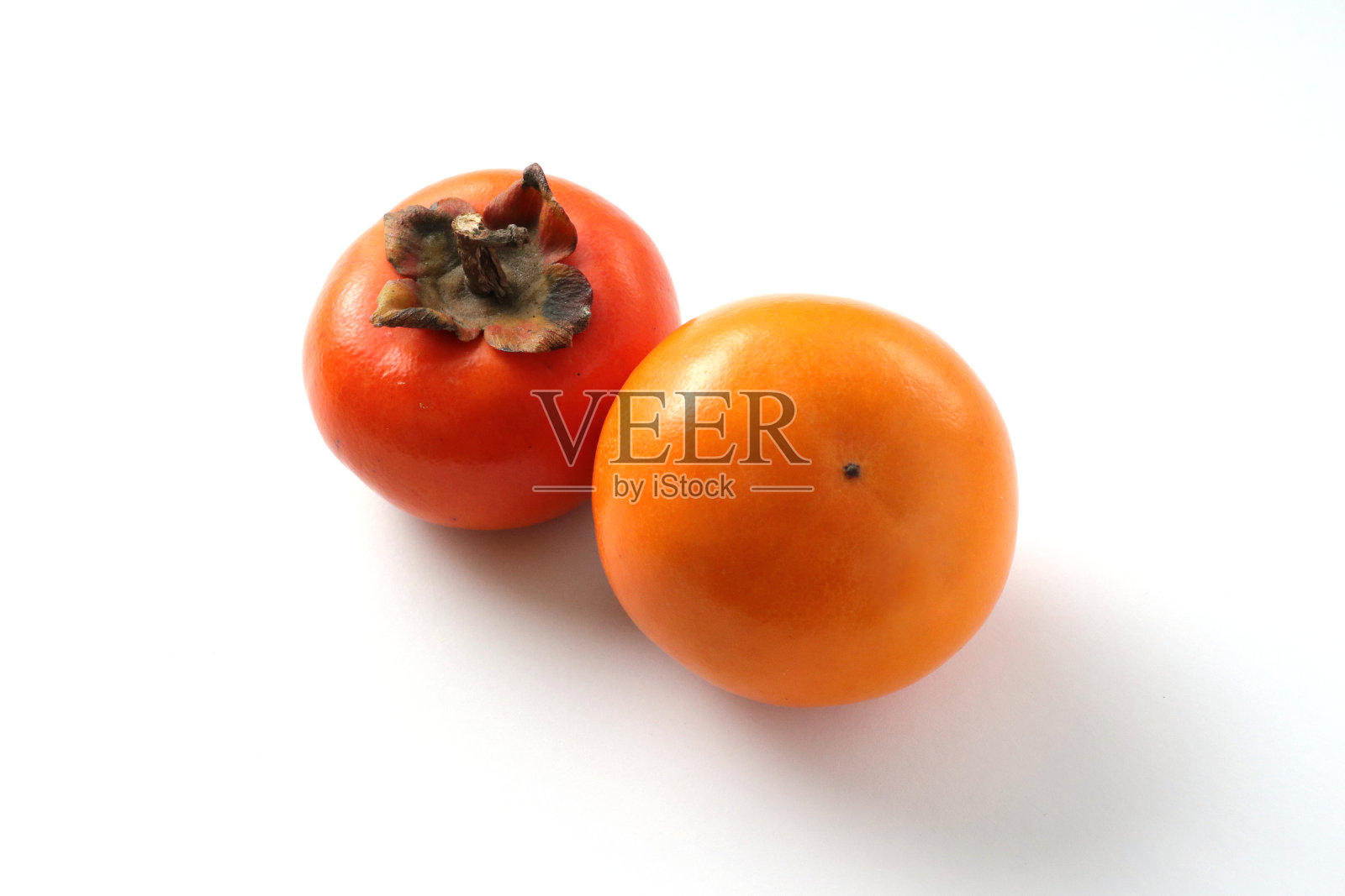 白底上的两个柿子。照片摄影图片