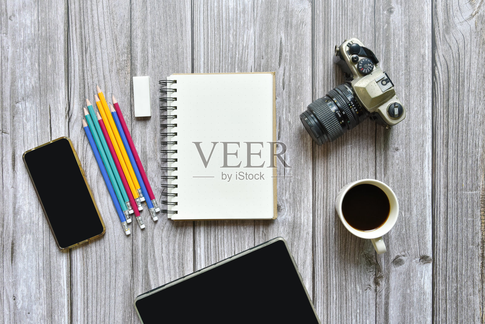 静物，商务或旅行者备忘录概念，顶部视图图像打开笔记本与复古相机咖啡彩色铅笔和平板与空白页上的老棕色木制背景，添加文本照片摄影图片