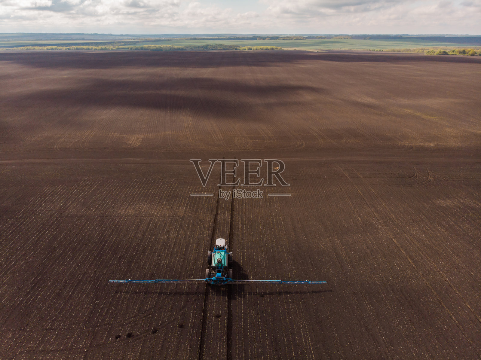 春耕在田间。拖拉机给庄稼喷除草剂、杀虫剂和杀虫剂照片摄影图片