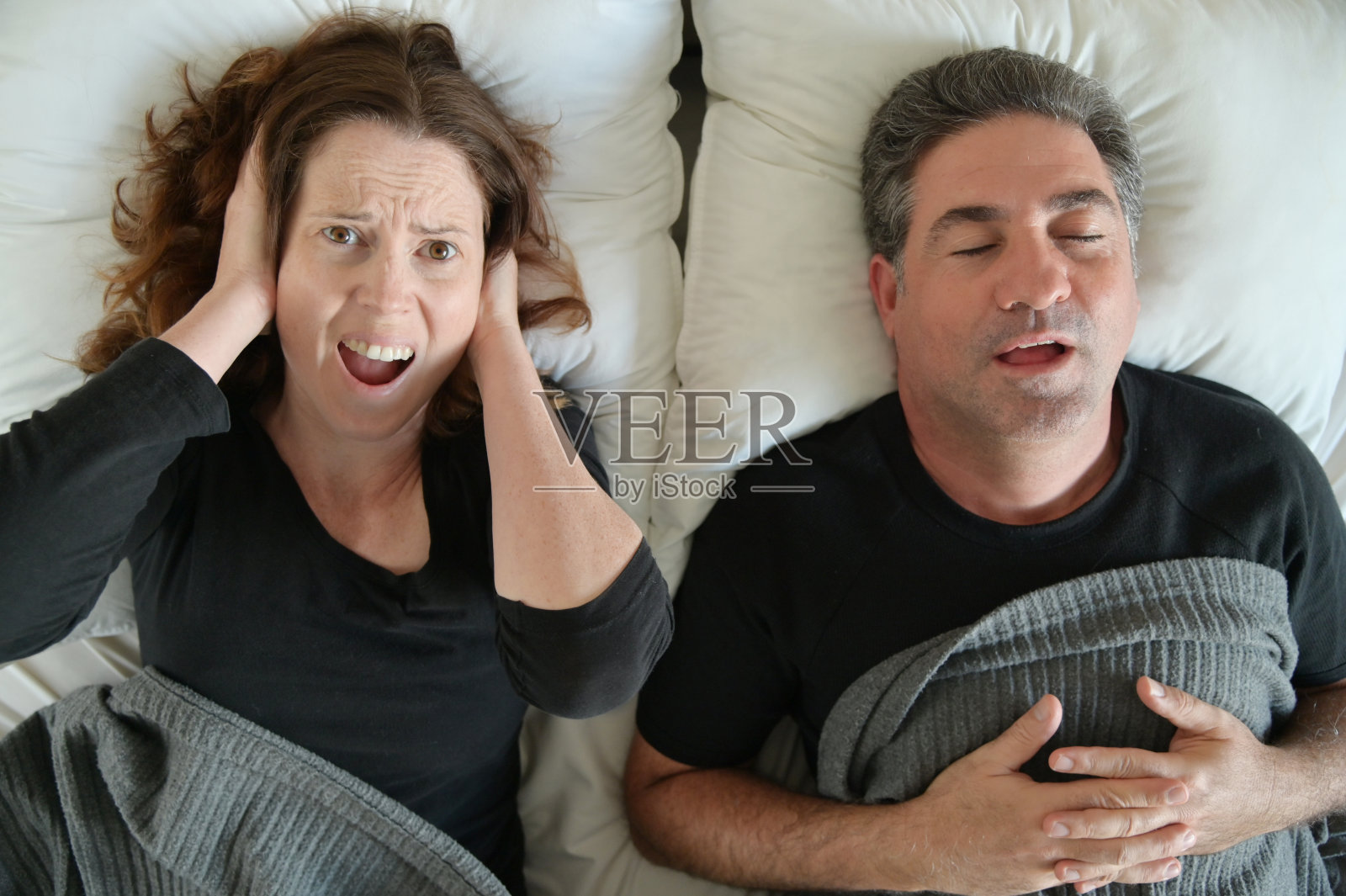 女人因男人在床上睡觉而打鼾照片摄影图片