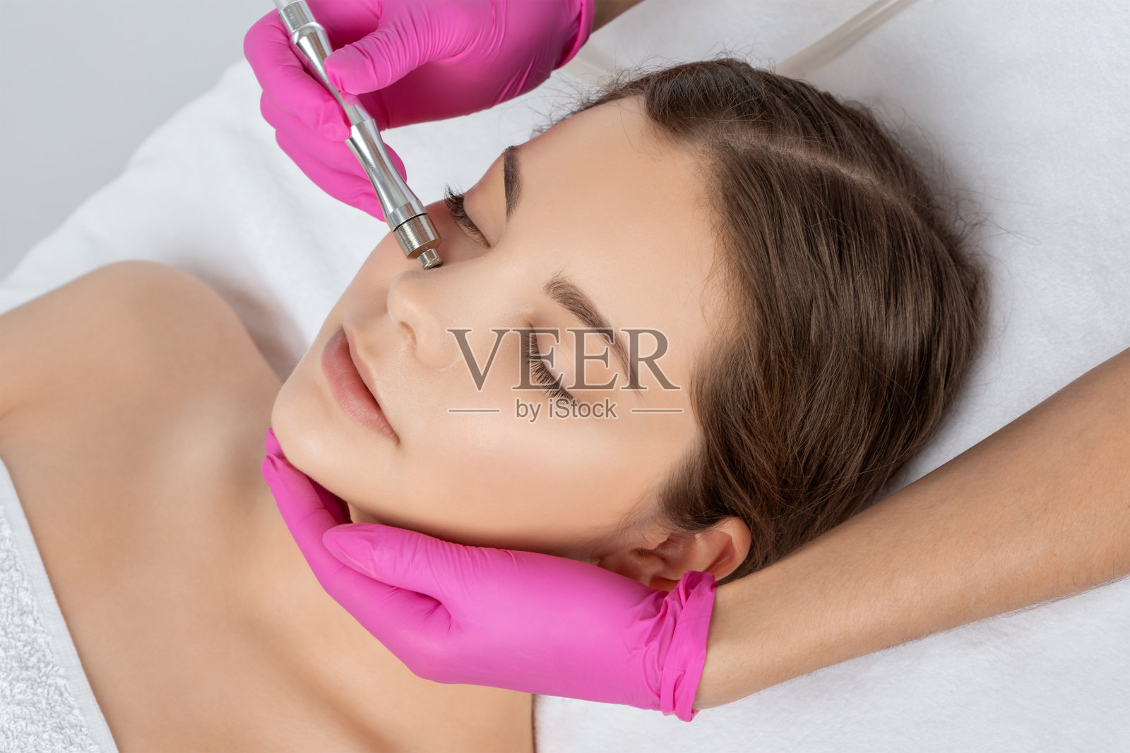 美容师使程序微晶磨砂脸部对抗痤疮和黑头附近的眼睛。美容院的女性美容。照片摄影图片