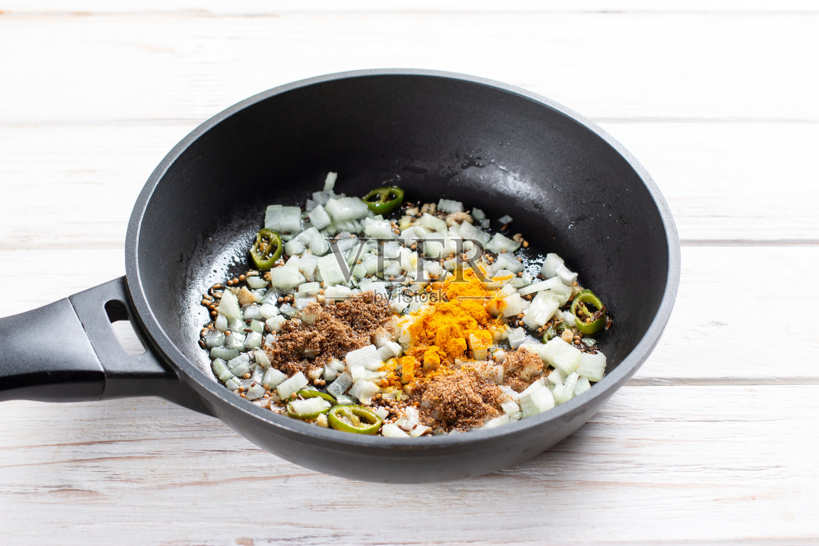 用平底锅用香料炒洋葱。烹饪戈壁的配料有椰菜和土豆，横放照片摄影图片