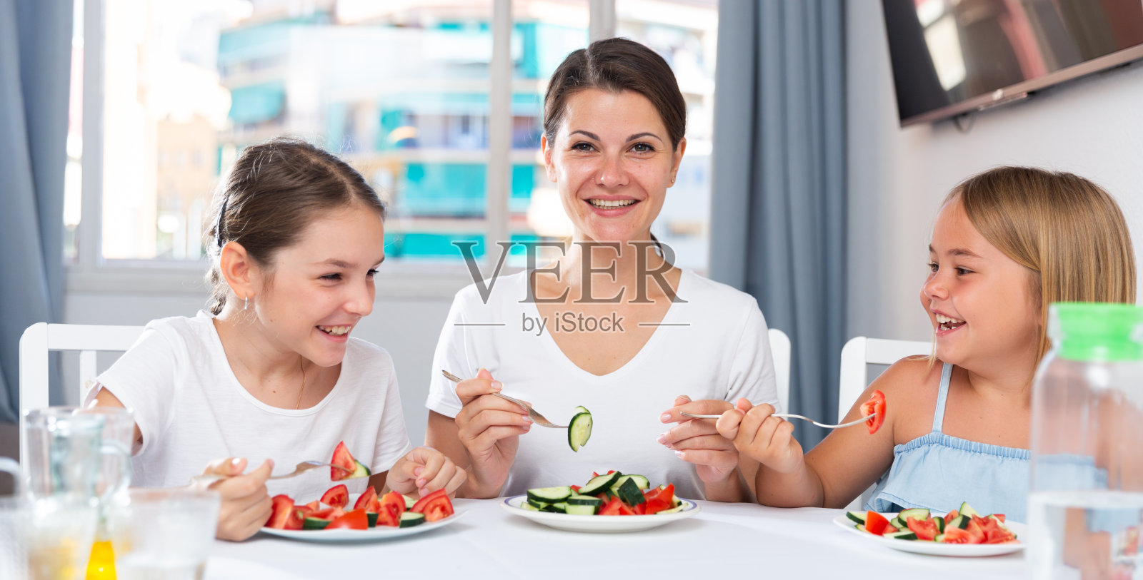 母女俩在房间里吃沙拉照片摄影图片