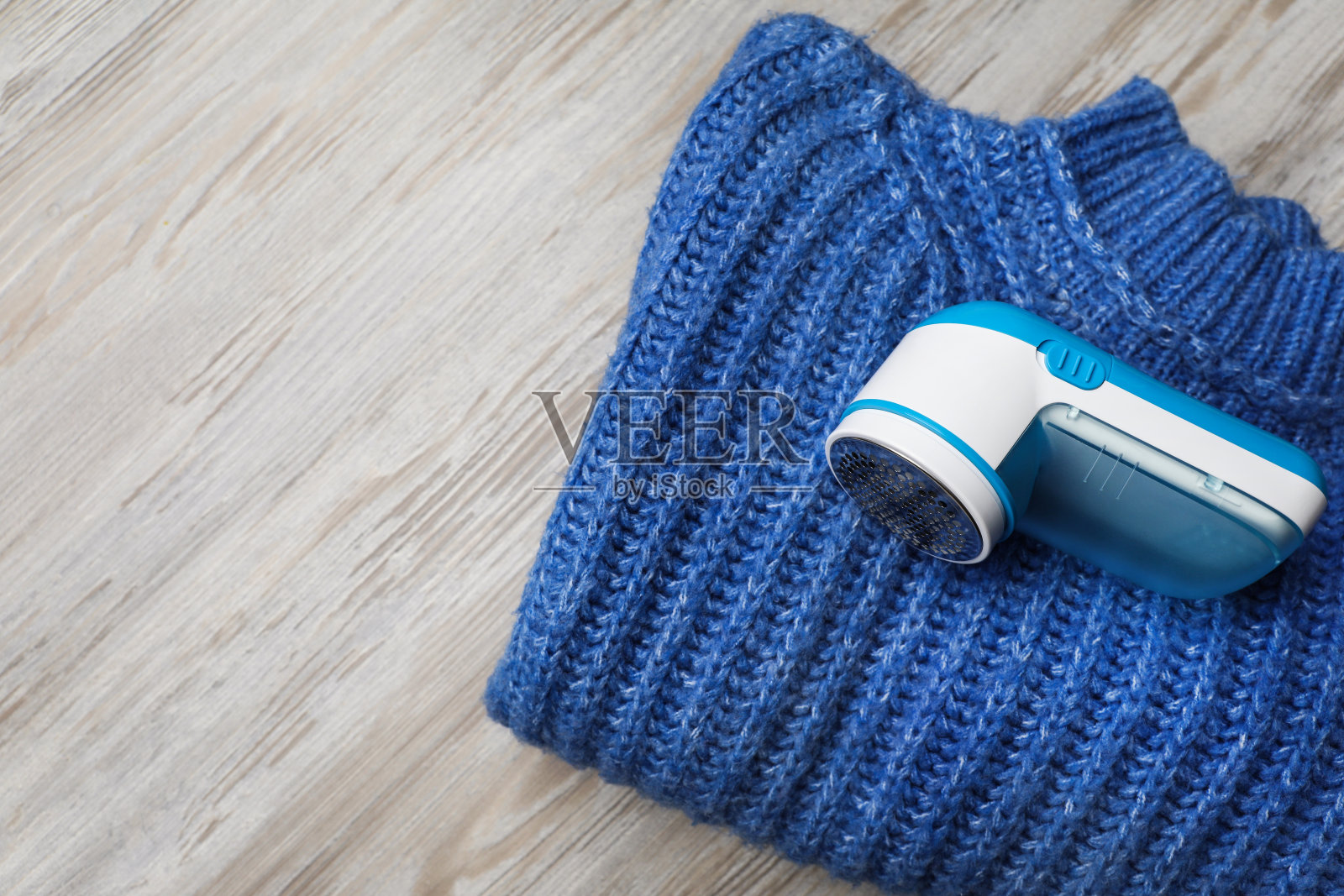 现代织物剃须刀，用于除绒和毛衣在木制桌子上，俯视图照片摄影图片