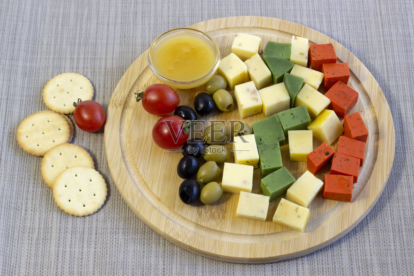 鲜亮不同的奶酪，鲜红和鲜绿的荷兰奶酪特写在木板上，孤立在白色的背景照片摄影图片