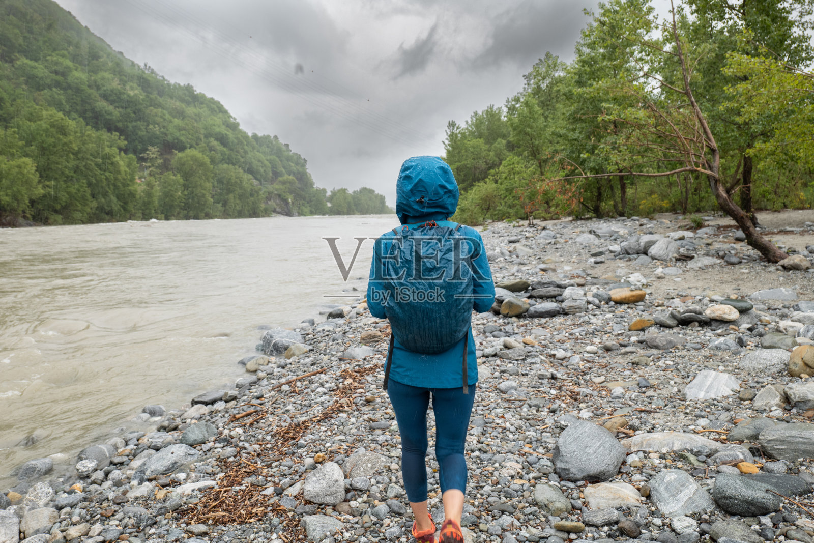 女徒步旅行者在暴雨中照片摄影图片