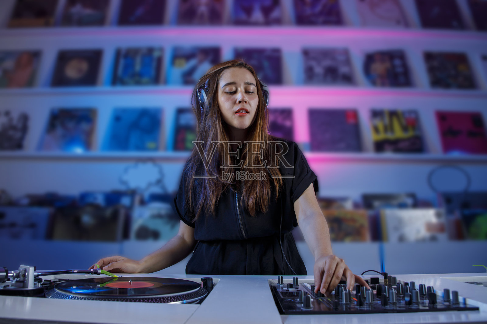 墨西哥dj女孩混合音乐在一个唱片店与转盘和黑胶唱片，复古的概念照片摄影图片