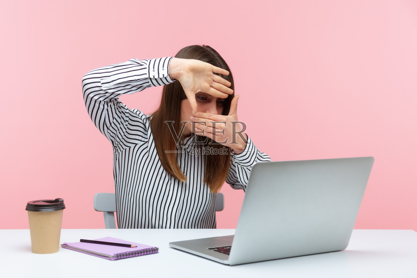 专注的女性设计师或摄影师双手制作相框，聚焦于笔记本电脑屏幕，裁剪图片，捕捉商业创意照片摄影图片