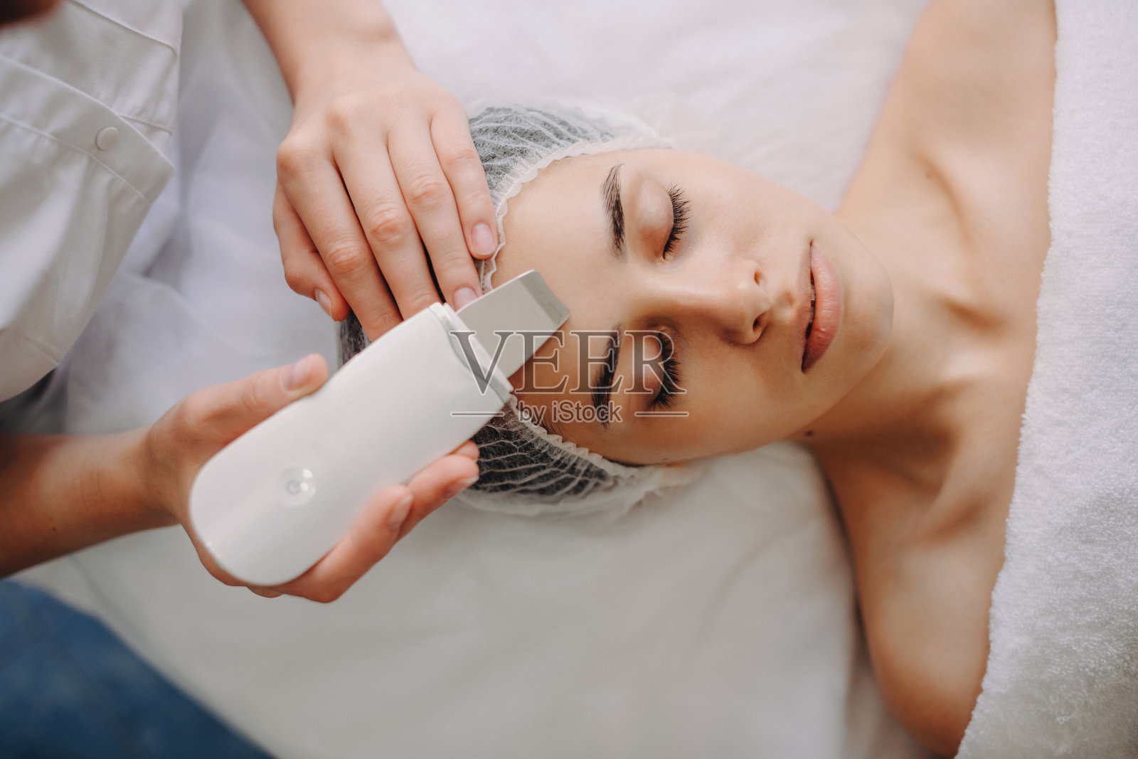 俯视图的照片，一个白人妇女躺着，而有专业的水疗程序与设备在沙龙照片摄影图片