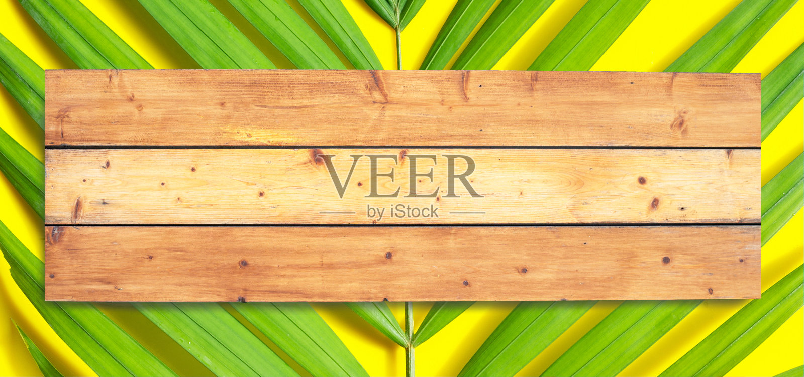 黄色表面上的热带棕榈叶木制空间。夏天背景概念照片摄影图片