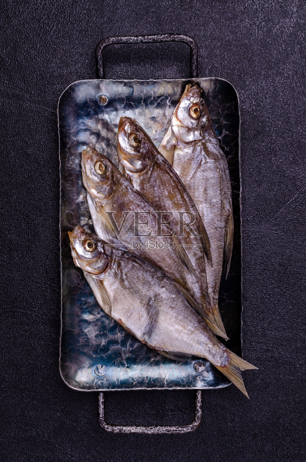 金属盘子上的鱼干照片摄影图片