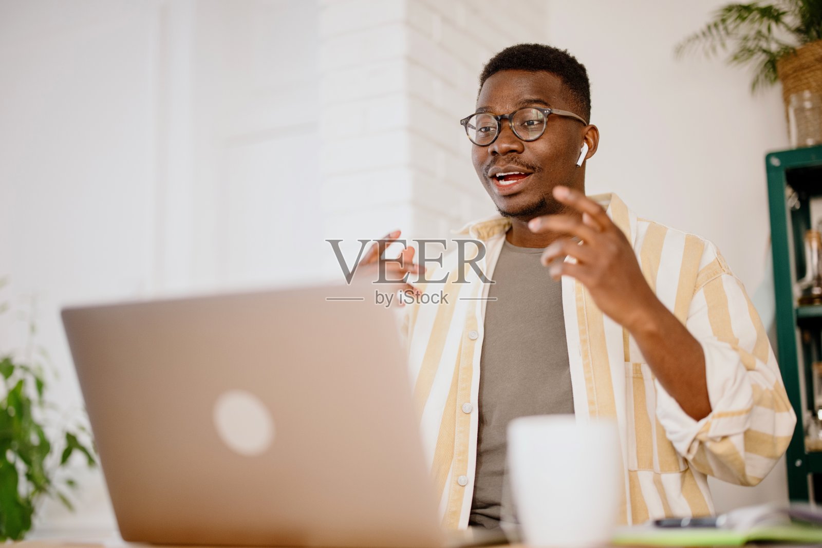 在家里工作的非洲人接听视频电话。听音乐，远程工作照片摄影图片