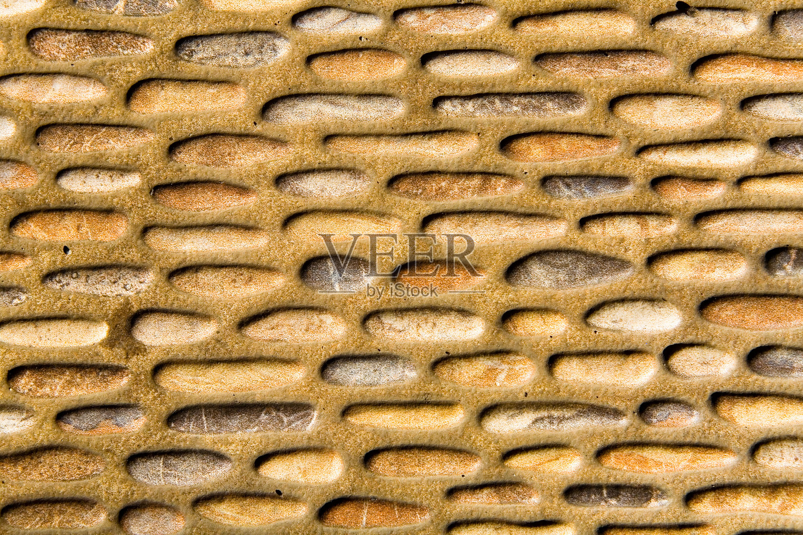 泥墙上非同寻常的石头版画。照片摄影图片