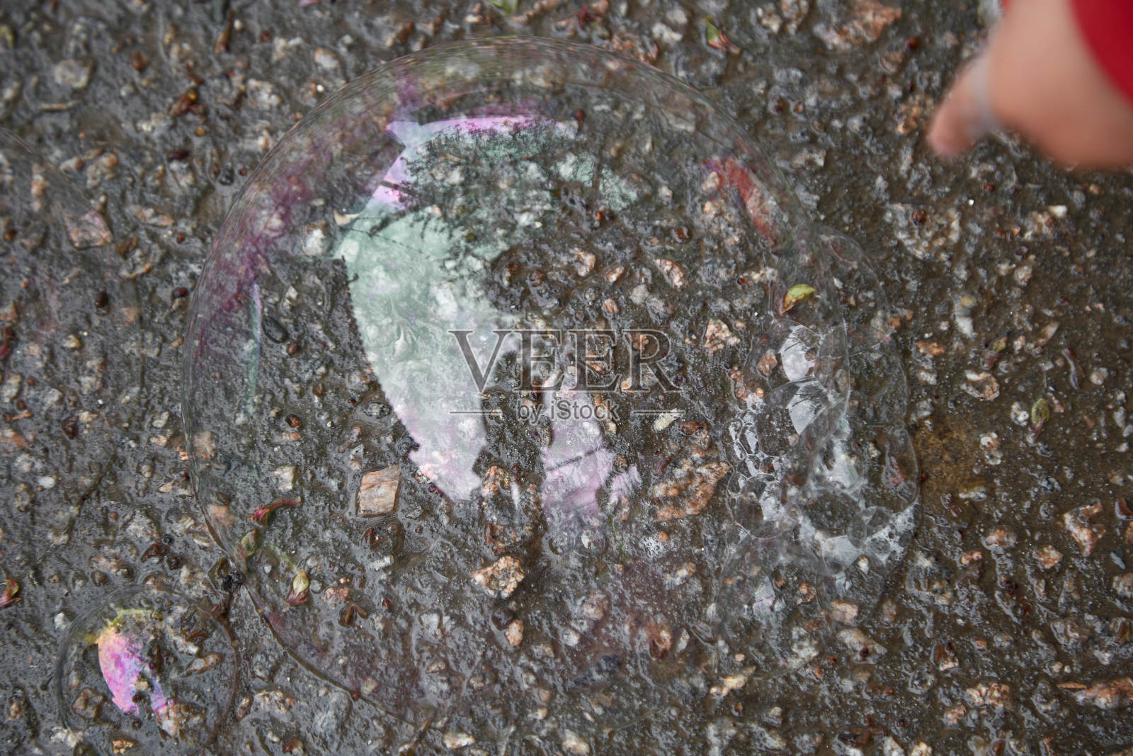 孩子的手指着一个肥皂泡。好奇心和探索世界的概念。Reflaction照片摄影图片