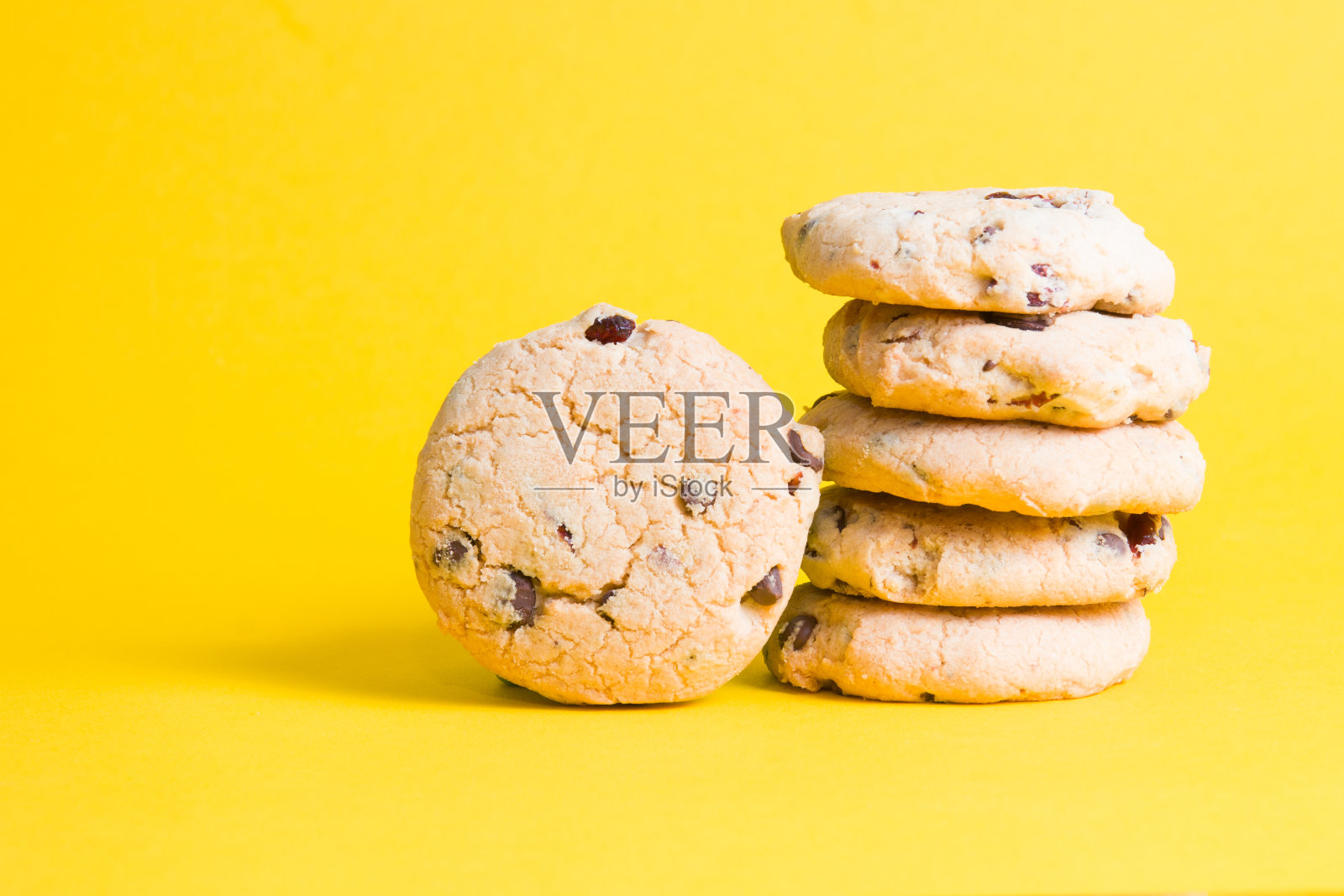 黄色背景的饼干，巧克力和越橘的饼干片照片摄影图片