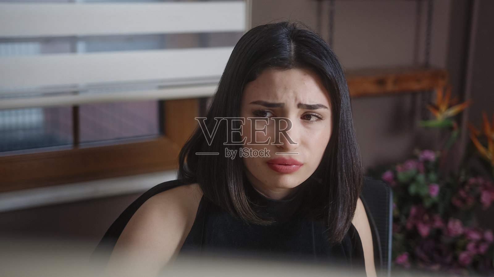 可悲的女人在家里用电脑工作。在家工作的概念。照片摄影图片