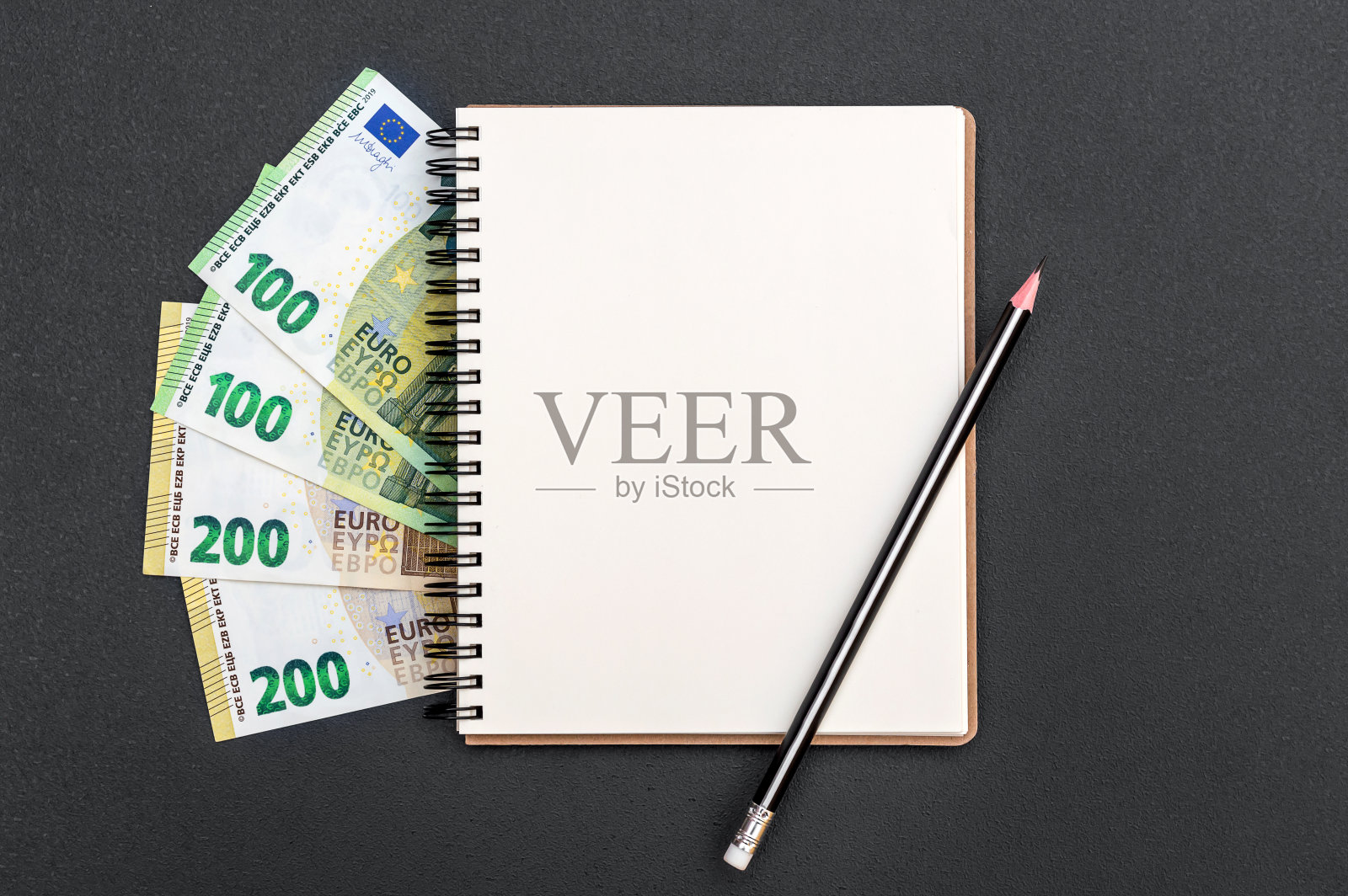 空白记事本上黑色的欧元钞票。经营理念。副本的空间。照片摄影图片