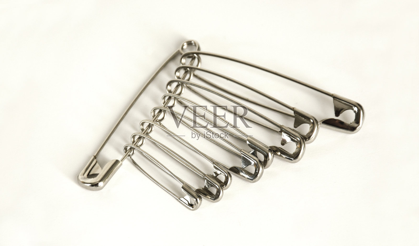 一束安全别针在灯光背景。照片摄影图片