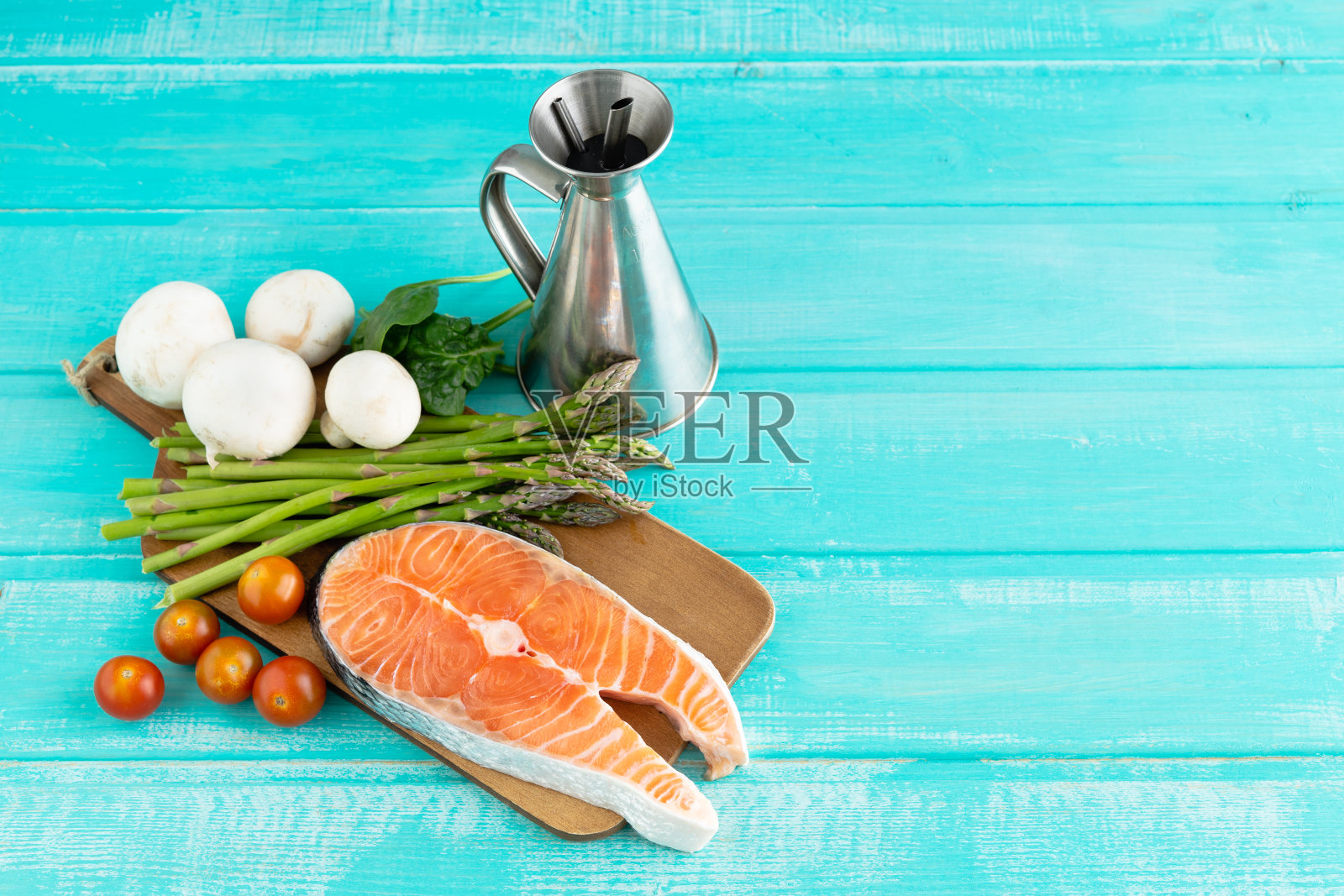 蓝色背景的新鲜鲑鱼片和蔬菜。副本的空间。照片摄影图片