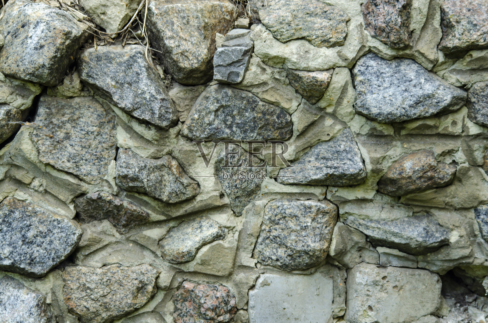 鹅卵石墙的大花岗岩石头。用水泥砂浆加固的石头墙照片摄影图片