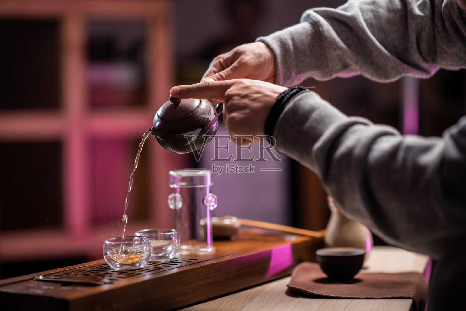 一名男子用特制的竹制功夫板招待客人喝正宗的成熟越南茶。东方饮茶传统照片摄影图片