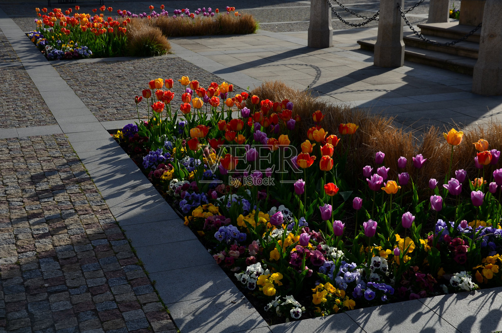 装饰性的花坛在一个规则的平面图中间用花岗岩铺成的广场。照片摄影图片