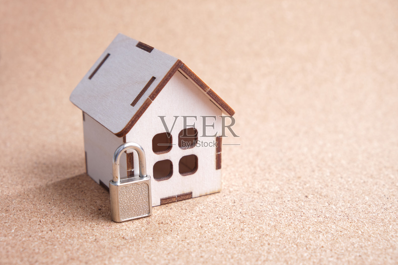 木制玩具屋和一个小挂锁上的软木板，财产保护概念照片摄影图片