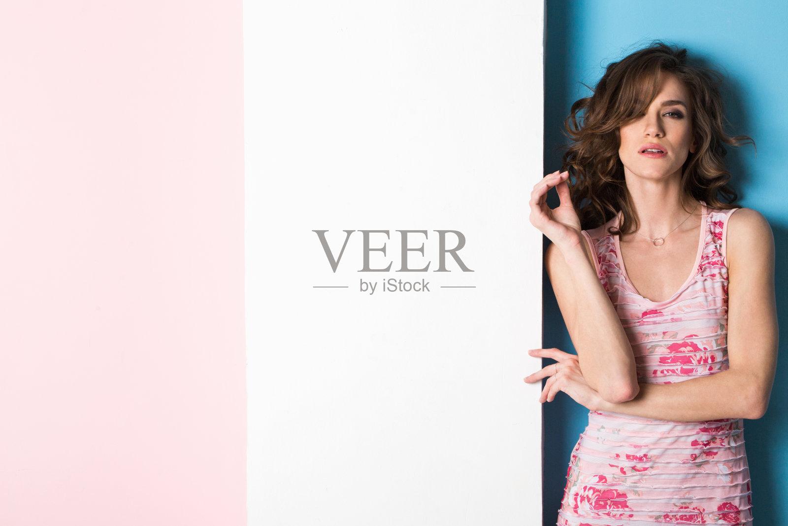 时尚美丽的女人看着相机在粉蓝色的背景工作室拍摄照片摄影图片