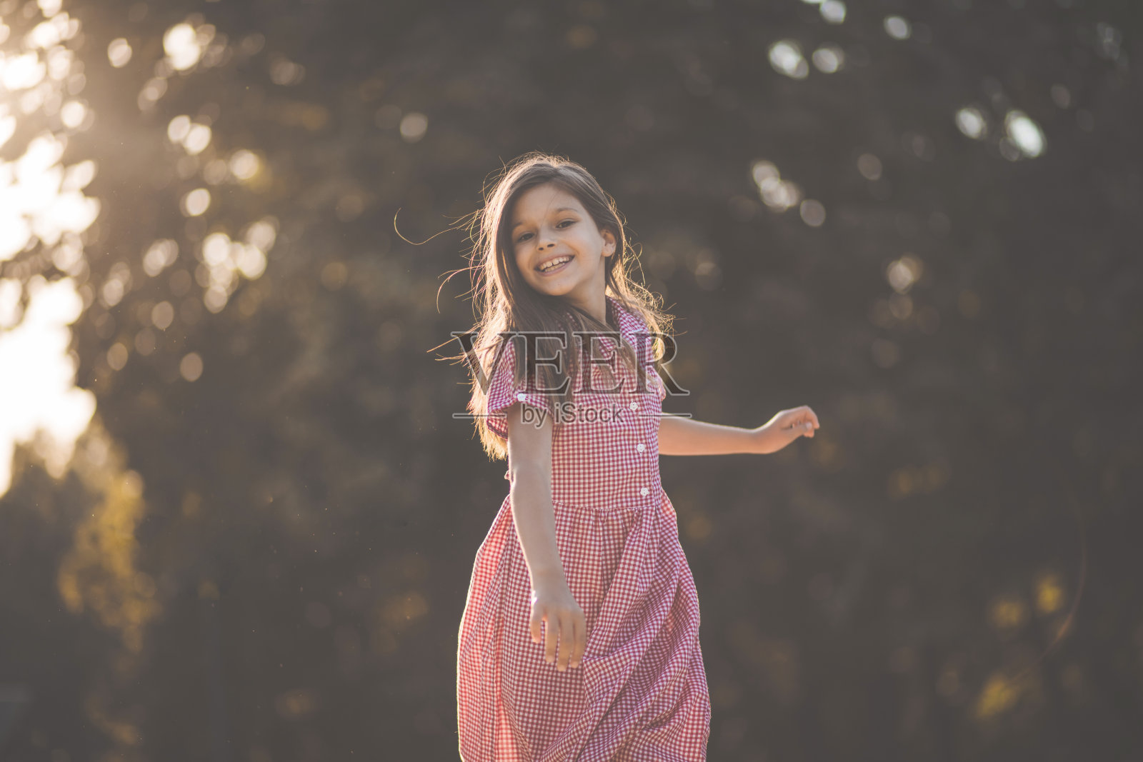 微笑的小女孩独自在大自然中奔跑。照片摄影图片