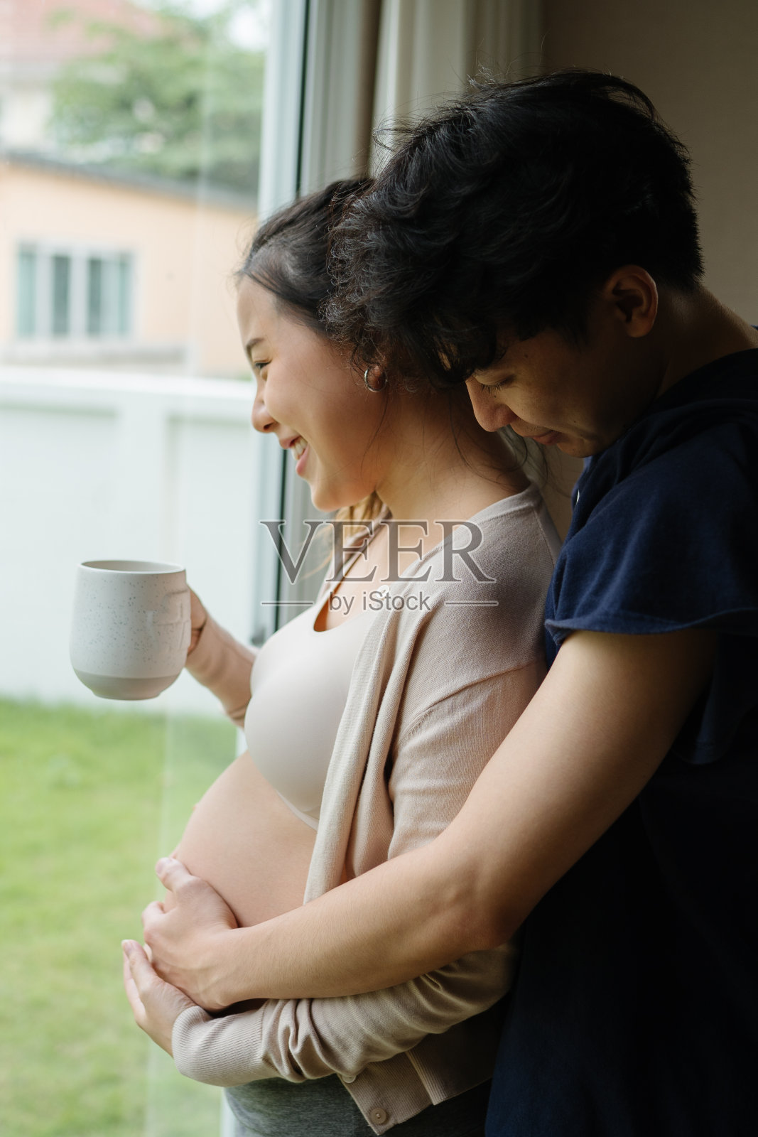 有爱的丈夫和怀孕的妻子在家。照片摄影图片