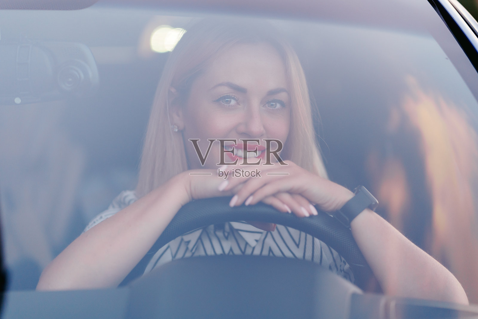 女人开着车，从前窗看出去照片摄影图片