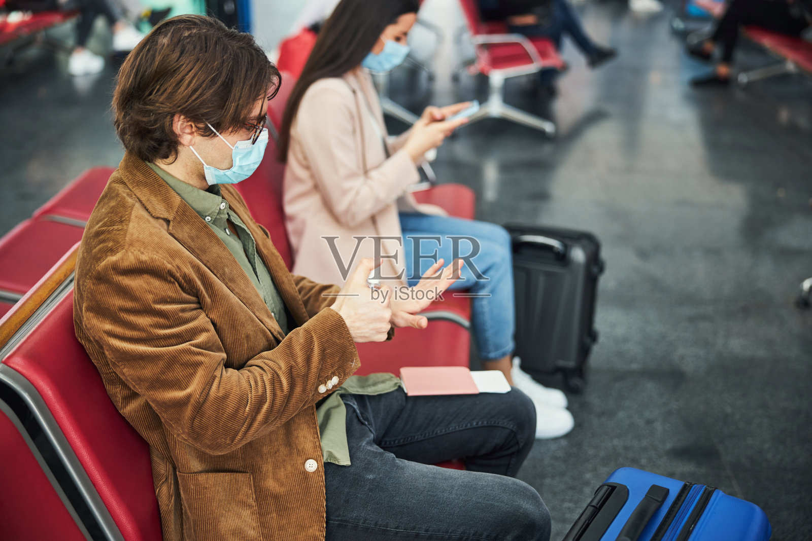 时尚男士戴医用口罩，在机场用洗手液洗手照片摄影图片