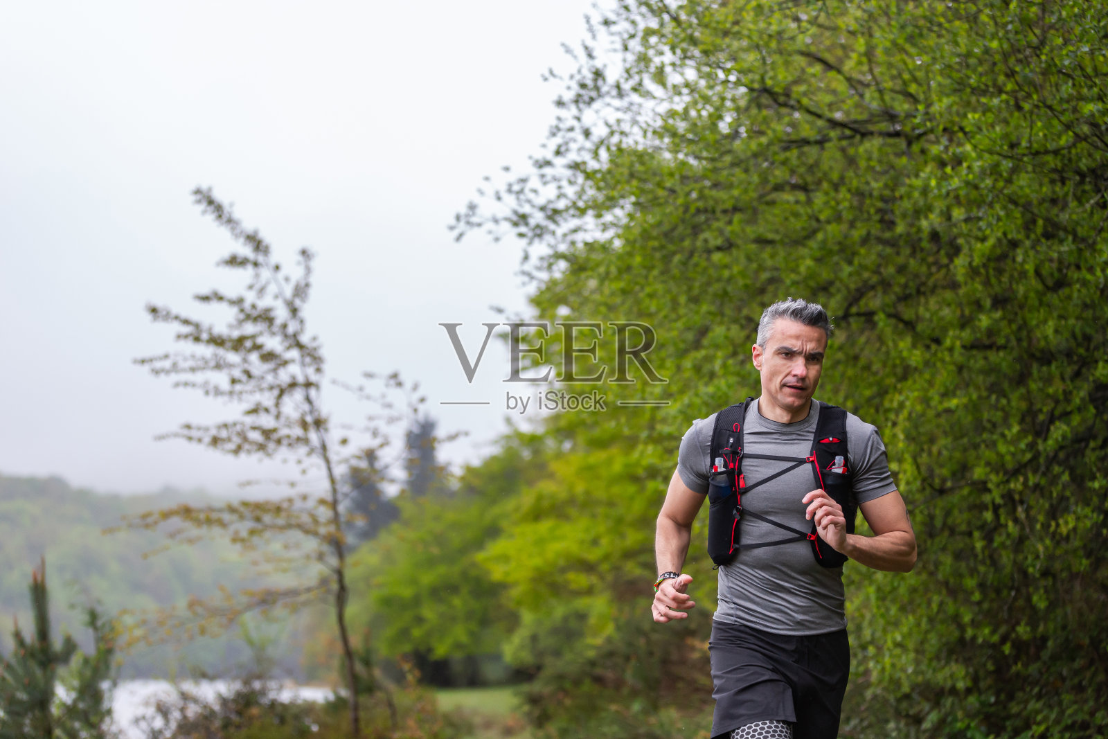 一个人在湖边的灌木丛里奔跑照片摄影图片