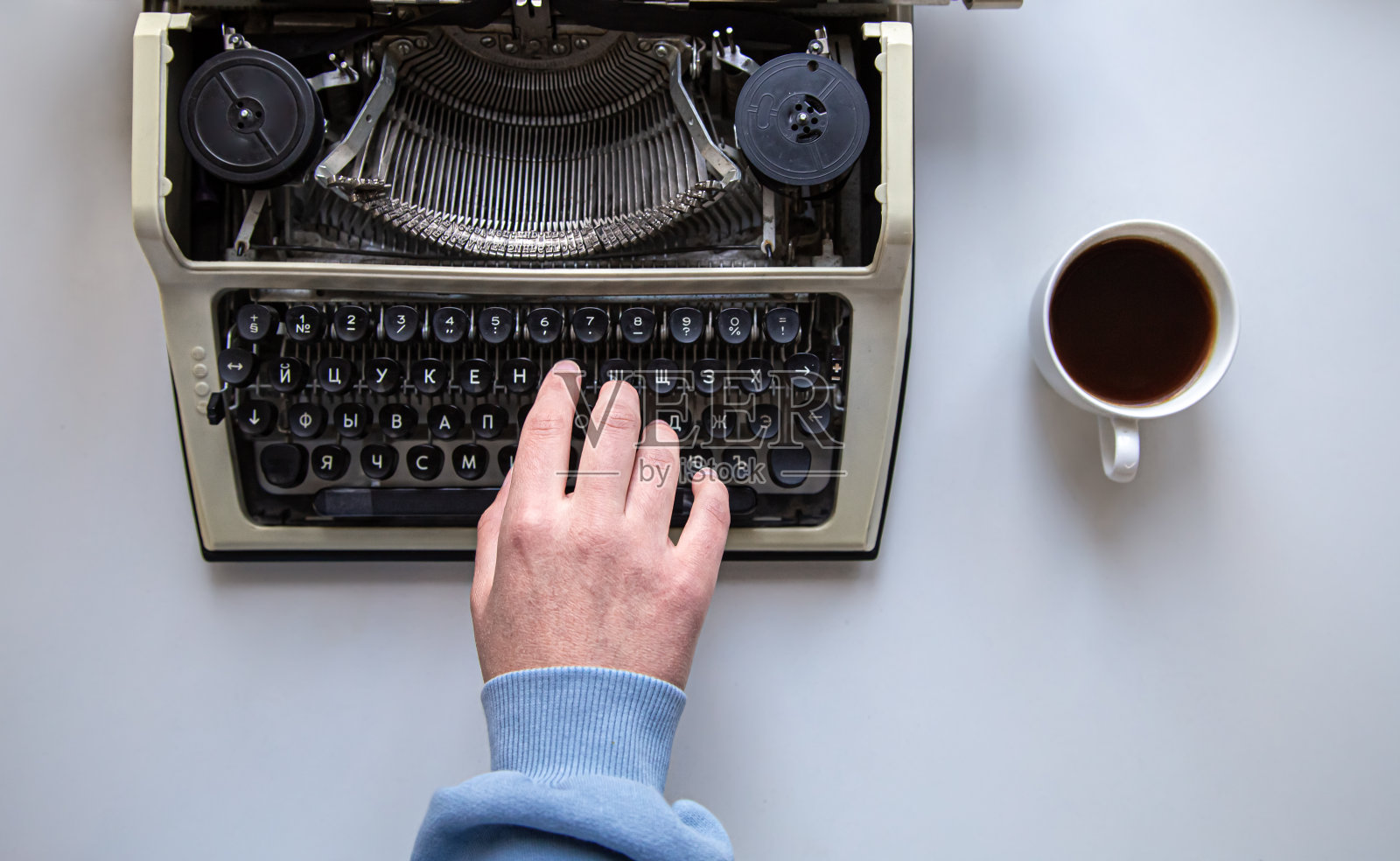 女人的手在老式打字机上打字俯视图。照片摄影图片