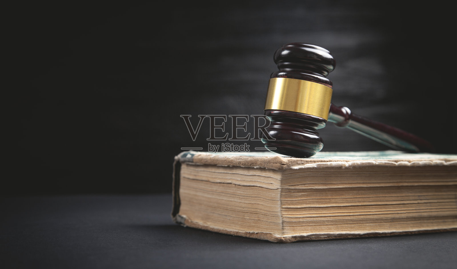 法官的木槌和书在黑色的背景上。照片摄影图片