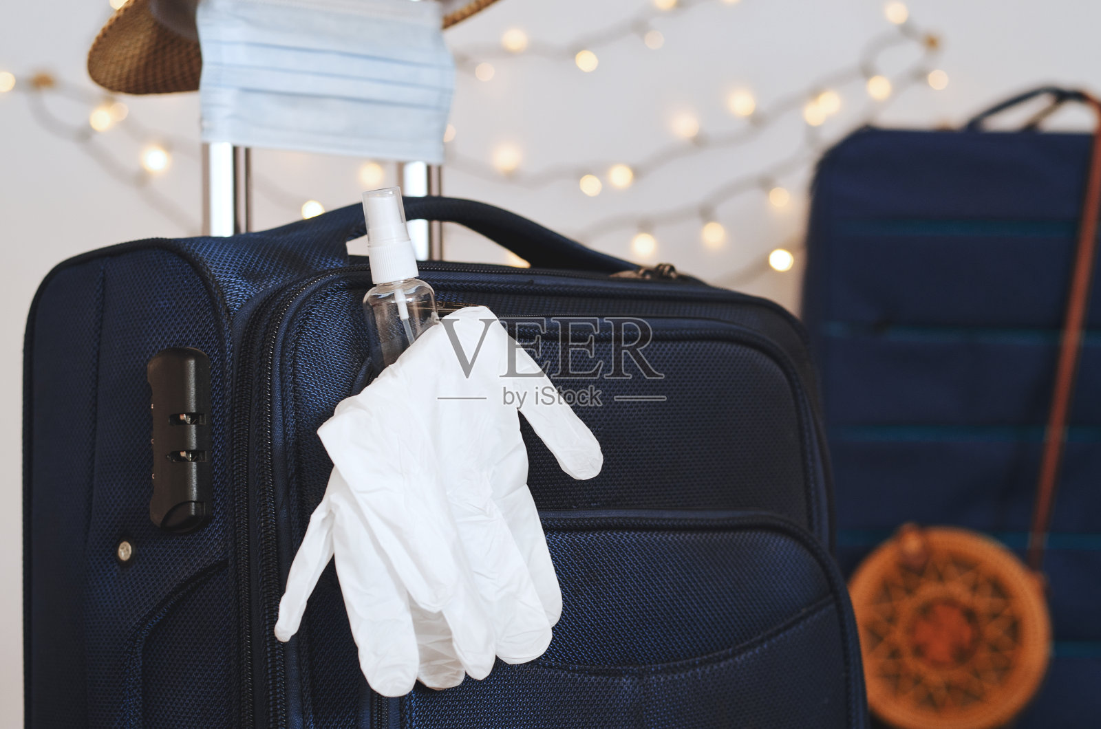 隔离结束后的旅行准备工作。新冠肺炎大流行后的新生命。行李上有医用口罩、手套、洗手液、太阳镜和沙帽。照片摄影图片