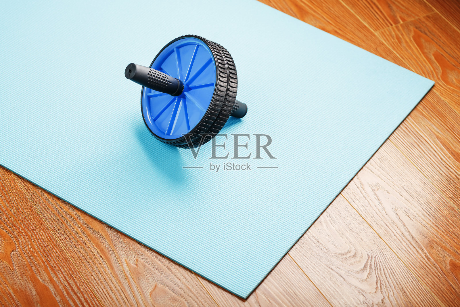 运动滚动训练肌肉和腹肌上的蓝色垫子。照片摄影图片