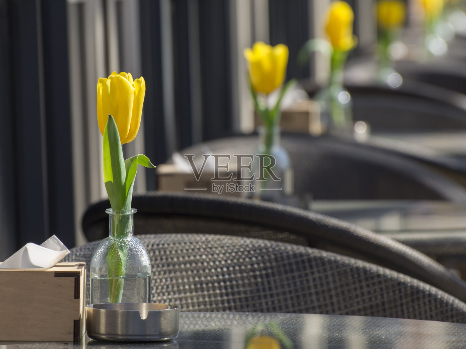 夏日咖啡馆桌上放着鲜花。放松平台和空桌子。隔离。照片摄影图片