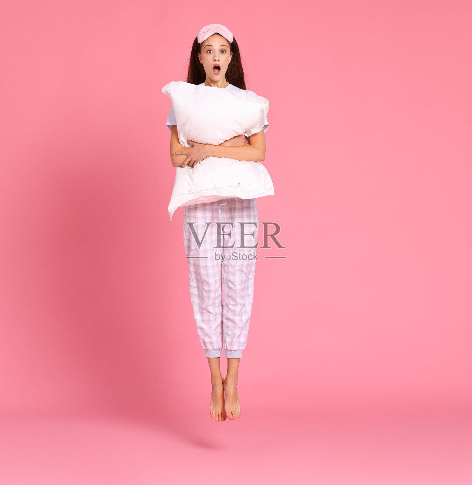 早上开心惊喜女抱枕头照片摄影图片