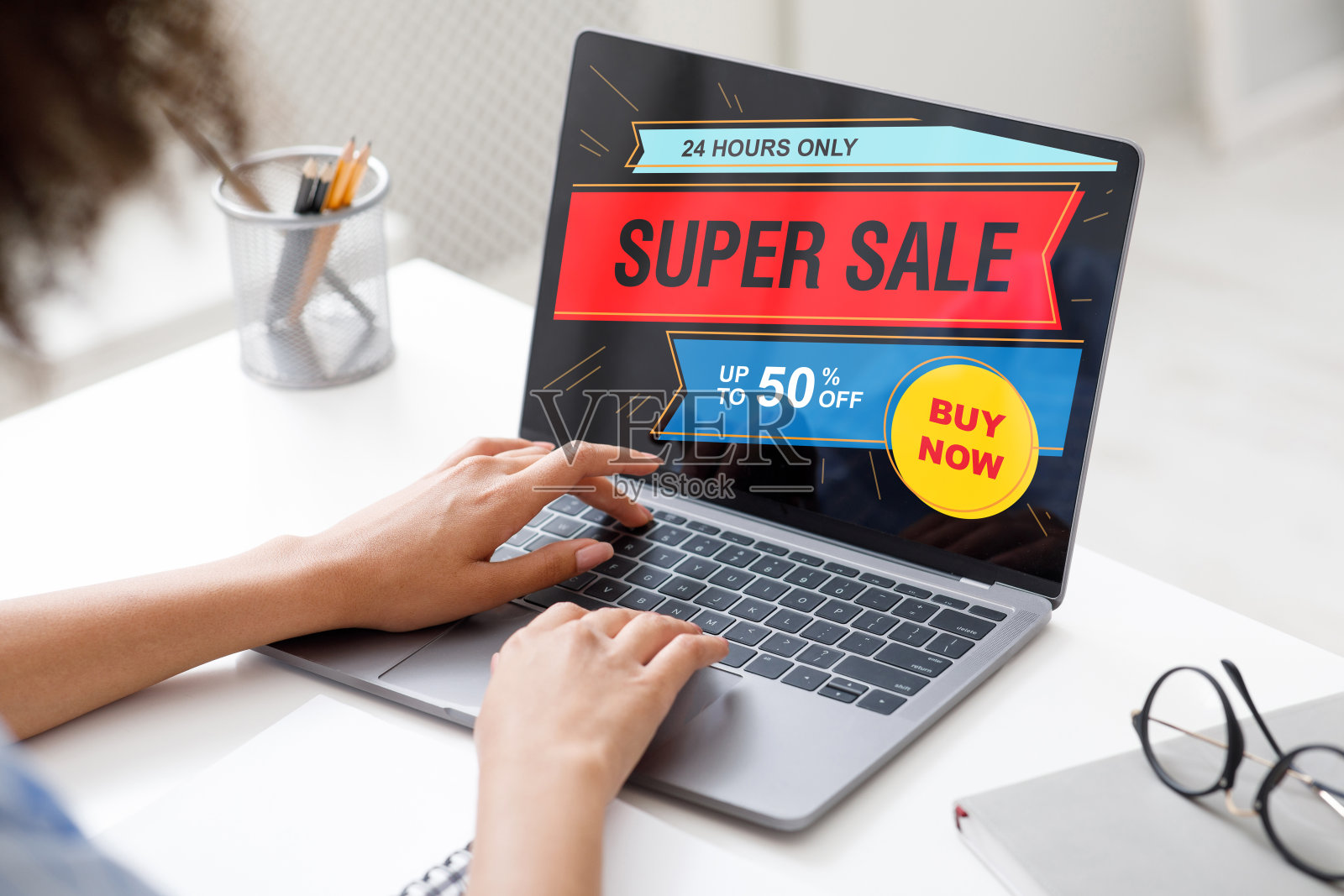 一位非裔美国女性在网上购物，在办公室使用笔记本电脑照片摄影图片