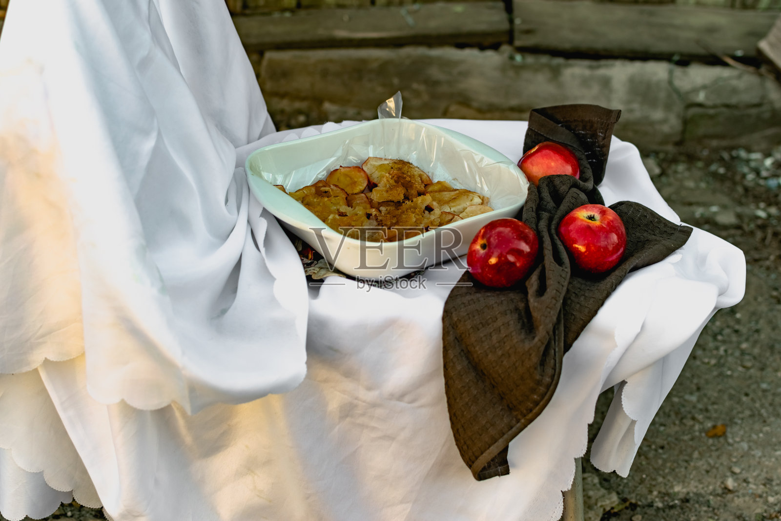 美味的烤苹果配肉桂和糖，用新鲜的红苹果装饰，不寻常的陶瓷烤箱菜肴照片摄影图片