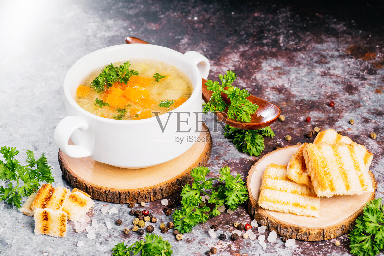 用木勺装在木板上的意大利面和蔬菜汤。特写镜头。照片摄影图片