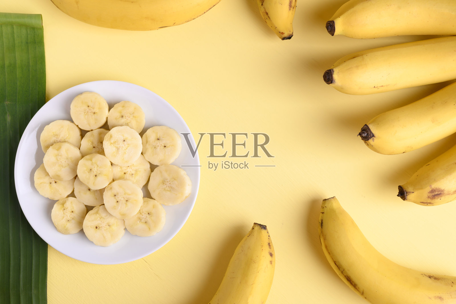 香蕉切片和成熟的香蕉果实在黄色的背景照片摄影图片