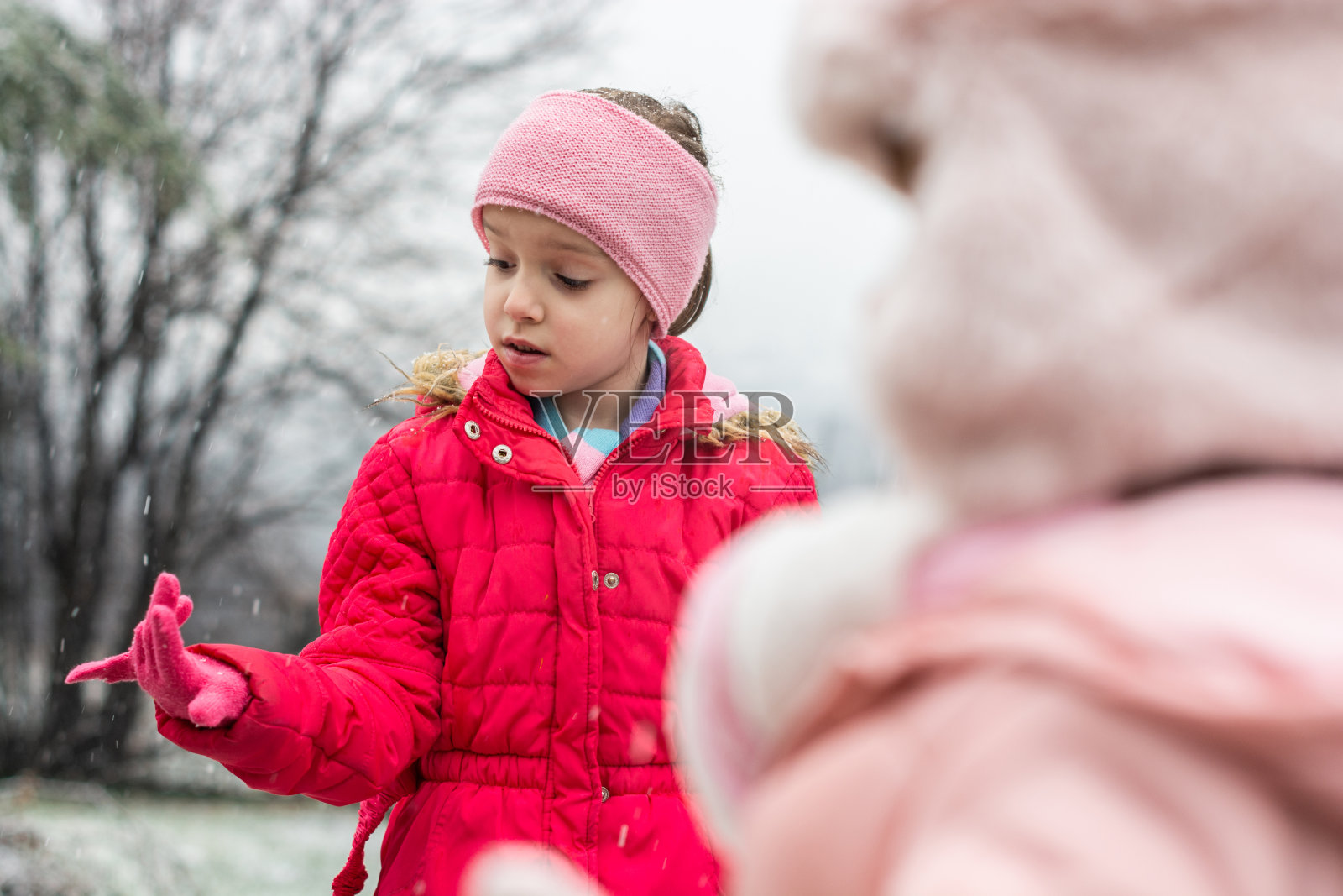 孩子在院子里抓雪花照片摄影图片