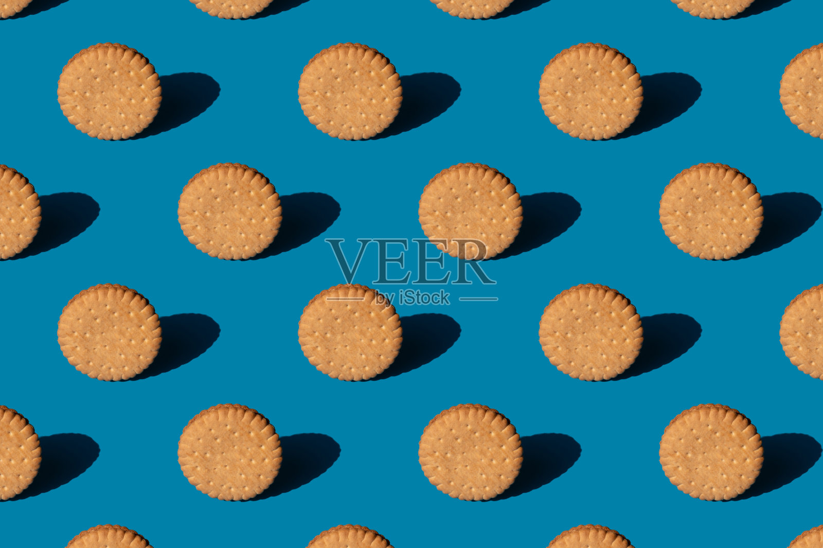 蓝色背景上的饼干图案。简约时尚的阳光概念照片摄影图片
